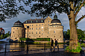 Young men go for a walk in front of the castle of Oerebro, Sweden