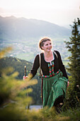 Young woman in traditional costume hiking on the Falkenstein in Allgaeu, Pfronten, Bavaria, Germany