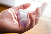 Hand of Caucasian woman holding crystal