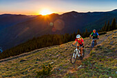 Caucasian couple mountain biking on trail