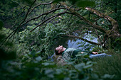Caucasian man relaxing in woods