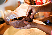 Hands of mixed race woman shaping clay in art studio