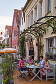 People sit outside 99er Kulinarium restaurant, Iphofen, Franconia, Bavaria, Germany