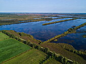 Aerial of people cycling along lakes and peat bog lands through Bourtanger Moor-Bargerveen International Nature Park, near Zwartemeer, Drenthe, Netherlands