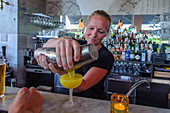 Frau mixt Drink in der Kneipe Urban Deli AB in SOFO , Stockholm, Schweden