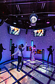 Tourists dance to Abba music in the Abba Museum, Stockholm, Sweden