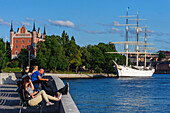 Jugendherberge auf dem Segelschiff Vandrarhem af Chapman und Skeppsholmen. Menschen davor auf Parkbank , Stockholm, Schweden