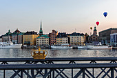 Blick von der Skeppsholmsbron mit Krone auf dem Geländer auf die Altstadt , Stockholm, Schweden