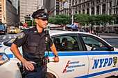 nypd police officer leaning against the door of his police car in the financial district of new york, patrolling as part of the fight against terrorism, new york police department, manhattan, new york city, state of new york, united states, usa