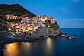 A long exposure at blue hour as the lights come on in the colourful town of Manarola, Cinque Terre, UNESCO World Heritage Site, Liguria, Italy, Europe