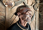 Bengshe Bengsha, elderly Naga tribal headhunter with traditional tattooed face and hair knot, Longwa village, Nagaland, India, Asia