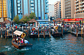 A water taxi carrying passengers arrives at a busy dock, Dubai Creek, Dubai, United Arab Emirates, Middle East