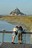 France, Lower Normandy Region, Manche Department, Mont St-Michel seen from the dam on Couesnon river, couple of visitors.