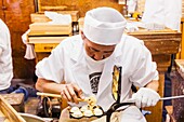 Japan, Honshu, Tokyo, Asakusa, Sensoji Temple aka Asakusa Kannon Temple, Nakamise Shopping Street, Man Making Traditional Cakes