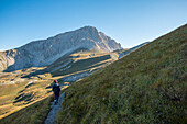Hiker on the path to the summit of peak Corno Grande, Gran Sasso e Monti della Laga National Park, Abruzzo, Italy, Europe