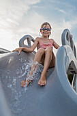 Low angle view of girl enjoying water slide against sky