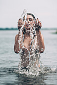 Sensuous woman splashing water in lake