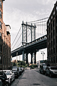 Manhattan Bridge against sky seen from city street, New York City, New York, USA