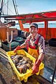 Fisherman with fish, Gager, Moenchgut, Ruegen Island, Mecklenburg-Western Pomerania, Germany