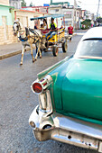 oldtimer and horse-drawn carriage on an empty street, colonial town, family travel to Cuba, parental leave, holiday, time-out, adventure, Cienfuegos, Cuba, Caribbean island