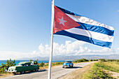 die kubanische Flagge weht am Snorkeling Snack ''La Batea'' an der einsamen Küstenstraße von La Boca nach Playa Ancon, unterwegs gibt es viele schöne kleine Strände, Pferdekutsche, Einsamkeit,  Naturverbundenheit, am Strand, türkisblaues Meer, Familienrei