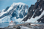 Expedition cruise ship MS Bremen (Hapag-Lloyd Cruises) awaits the return of its passengers after shore excursion, Paradise Bay (Paradise Harbor), Danco Coast, Graham Land, Antarctica