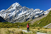 Frau wandert durch Hooker Valley, Mount Cook im Hintergrund, Hooker Valley, Mount Cook Nationalpark, UNESCO Welterbe Te Wahipounamu, Canterbury, Südinsel, Neuseeland