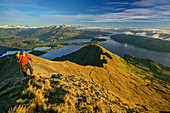 Frau steigt zum Roys Peak auf, Lake Wanaka und Mount Aspiring im Hintergrund, Roys Peak, Harris Mountains, Mount Aspiring Nationalpark, UNESCO Welterbe Te Wahipounamu, Queenstown-Lake District, Otago, Südinsel, Neuseeland