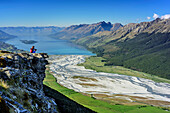 Woman hiking looking towards Dart River Valley and Lake Wakatipu, from Mount Alfred, Fiordland National Park, UNESCO Welterbe Te Wahipounamu, Queenstown-Lake District, Otago, South island, New Zealand
