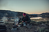 woman cooking an instant meal, greenland, arctic.