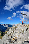 Frau beim Wandern steht am Gipfel des Sonnjoch und blickt auf Karwendelkette, Sonnjoch, Karwendel, Naturpark Karwendel, Tirol, Österreich