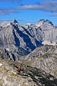 Frau beim Wandern steigt zum Sonnjoch auf, Kaltwasserkarspitze, Birkkarspitze und Ödkarspitze im Hintergrund, Sonnjoch, Karwendel, Naturpark Karwendel, Tirol, Österreich