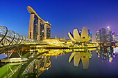 Beleuchtete Skyline von Singapur mit Helixbridge, Marina Bay Sands und ArtScience Museum spiegelt sich in Marina Bay, Singapur