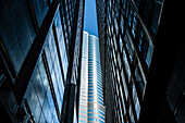 View from a narrow dark skyscraper canyon to a high-rise building in the sunlight, Hong Kong, China, Asia