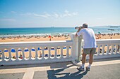 Man at the viewpoint over the beach. El Sardinero, Santander, Spain.