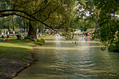 People bathing and relaxing at Eisbach in the Englischer Garten, Munich, Upper Bavaria, Germany