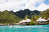 FRENCH POLYNESIA, Moorea. A boat ride with the Intercontinental Moorea Resort and Spa in the background.