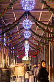 ITALY, Venice. Christmas decorations hangs along the crowded Procuratie Nuove in St. Mark's Square.