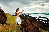 EASTER ISLAND, CHILE, Isla de Pascua, Rapa Nui, Ariki Vahine, Queen of the Island stands on the cliffside near the ocean