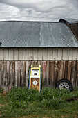 USA, Oregon, Enterprise, an old gas pump leans up against the side of a barn at the Snyder Ranch in Northeast Oregon