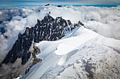 Mountain climbers departing Aiguille du midi, Aiguille du Plan summit in the background; Chamonix-Mont-Blanc, Haute-Savoie, France