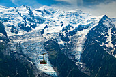 Close view of Mont Blanc and Brevent cable car under blue sky; Chamonix-Mont-Blanc, Haute-Savoie, France