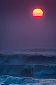 Smoke in the air colors the sun on a summer evening; Seaside, Oregon, United States of America