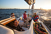 Group of people sailing in boat in sea at sunset, Perth, Western Australia, Australia