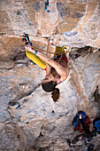 View from above of young woman rock climbing, Kalymnos, Greece