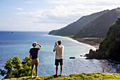 Rear view of adult couple admiring ocean coastline, Bali, Indonesia