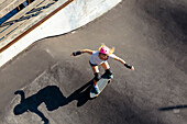View from above of woman skateboarding in skate park, Canggu, Bali, Indonesia