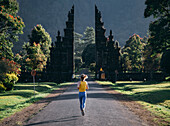Rear view of woman jogging on road, Bali, Indonesia