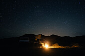 Group of friends sitting by bonfire at night, Fuerteventura, Canary Islands, Spain