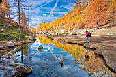 A tourist staring at the small lake near Crampiolo known as Witches Lake, Alpe Veglia and Alpe Devero Natural Park, Baceno, Verbano Cusio Ossola province, Piedmont, Italy